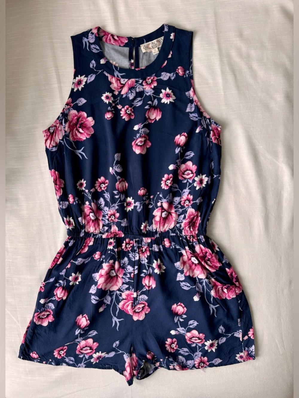 Women’s sleeveless navy romper with pink floral pattern, size medium, worn once